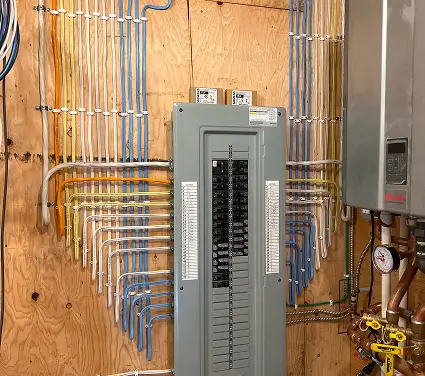 A panel of electrical wires connected to a water heater, showcasing the electrical setup for heating water.