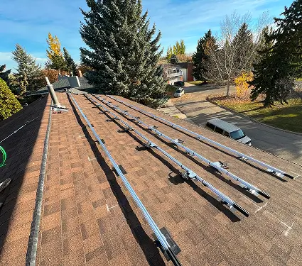 Solar panels installed on a residential roof, showcasing renewable energy technology in a suburban setting.