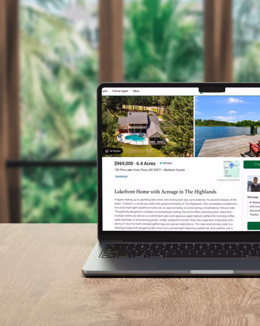 Open laptop on wooden table showing Hopper Real Estate Leaders listing for a $969,000 lakefront home on 6.4 acres in Flora, Mississippi, featuring aerial photos of a home with a pool and a dock on a lake.