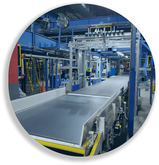 Empty modern factory conveyor belt system inside an industrial facility with blue structural elements.