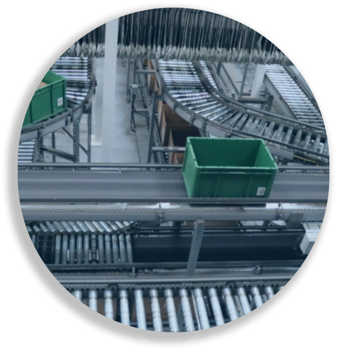 Green plastic bin on a metal roller conveyor system in a warehouse or distribution center.