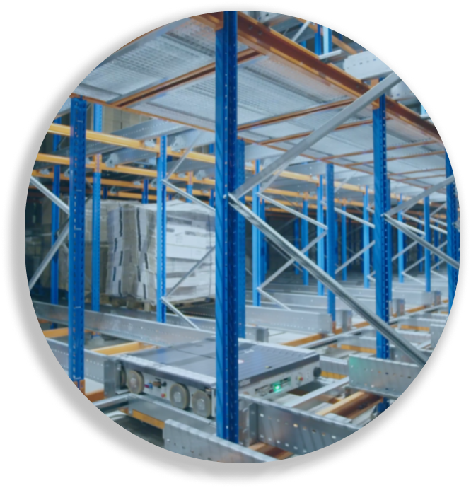 Automated storage system with blue racks holding pallets and a robotic platform moving below.