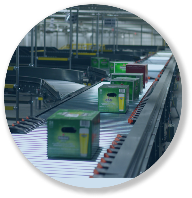 Boxes of Heineken beer on a conveyor belt in a factory setting.