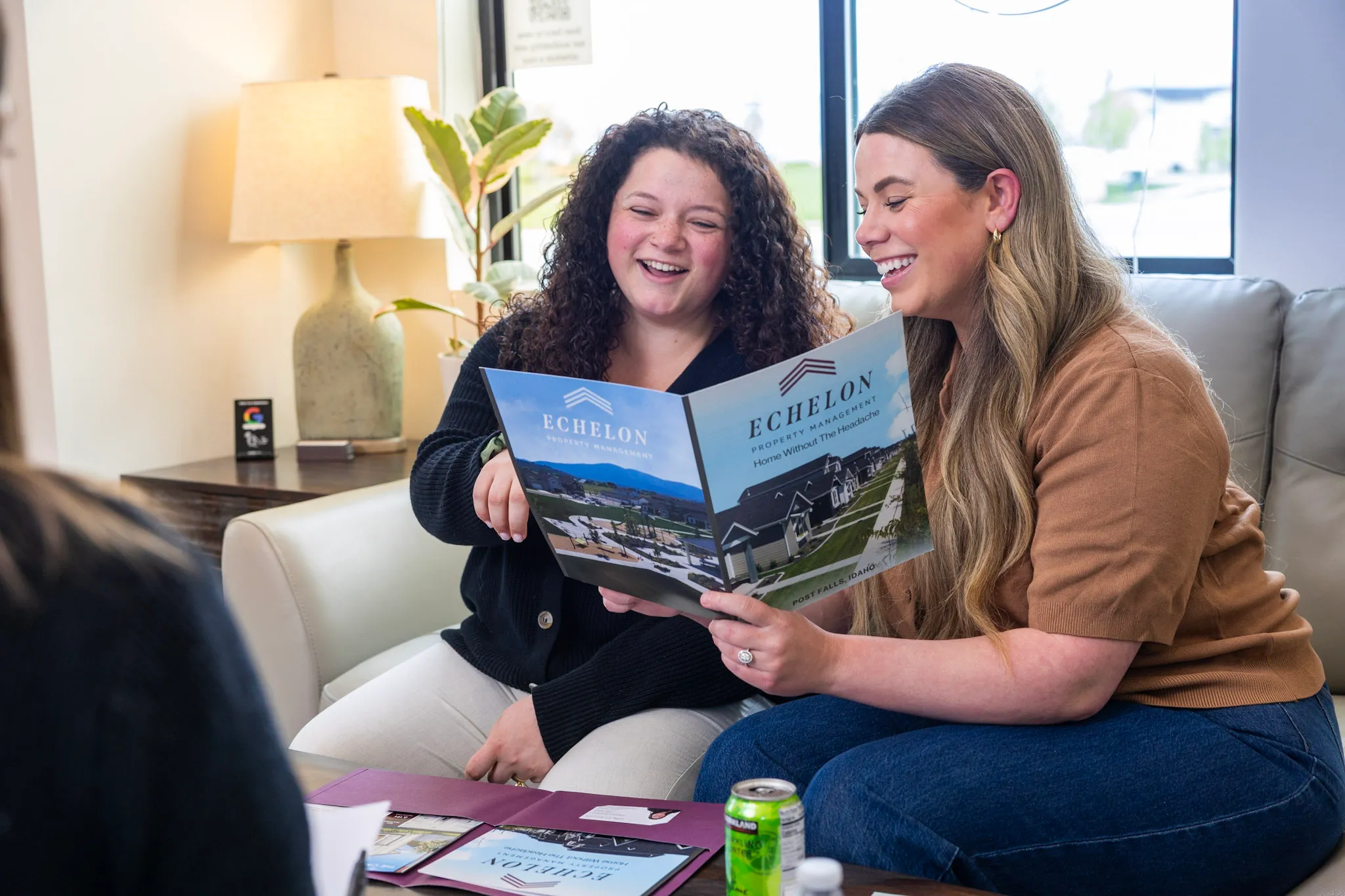 Two residents smiling as they review an Echelon leasing brochure