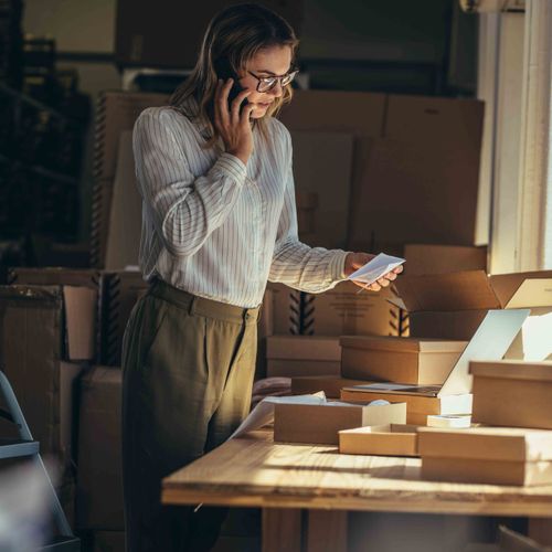 business owner standing at desk on phone
