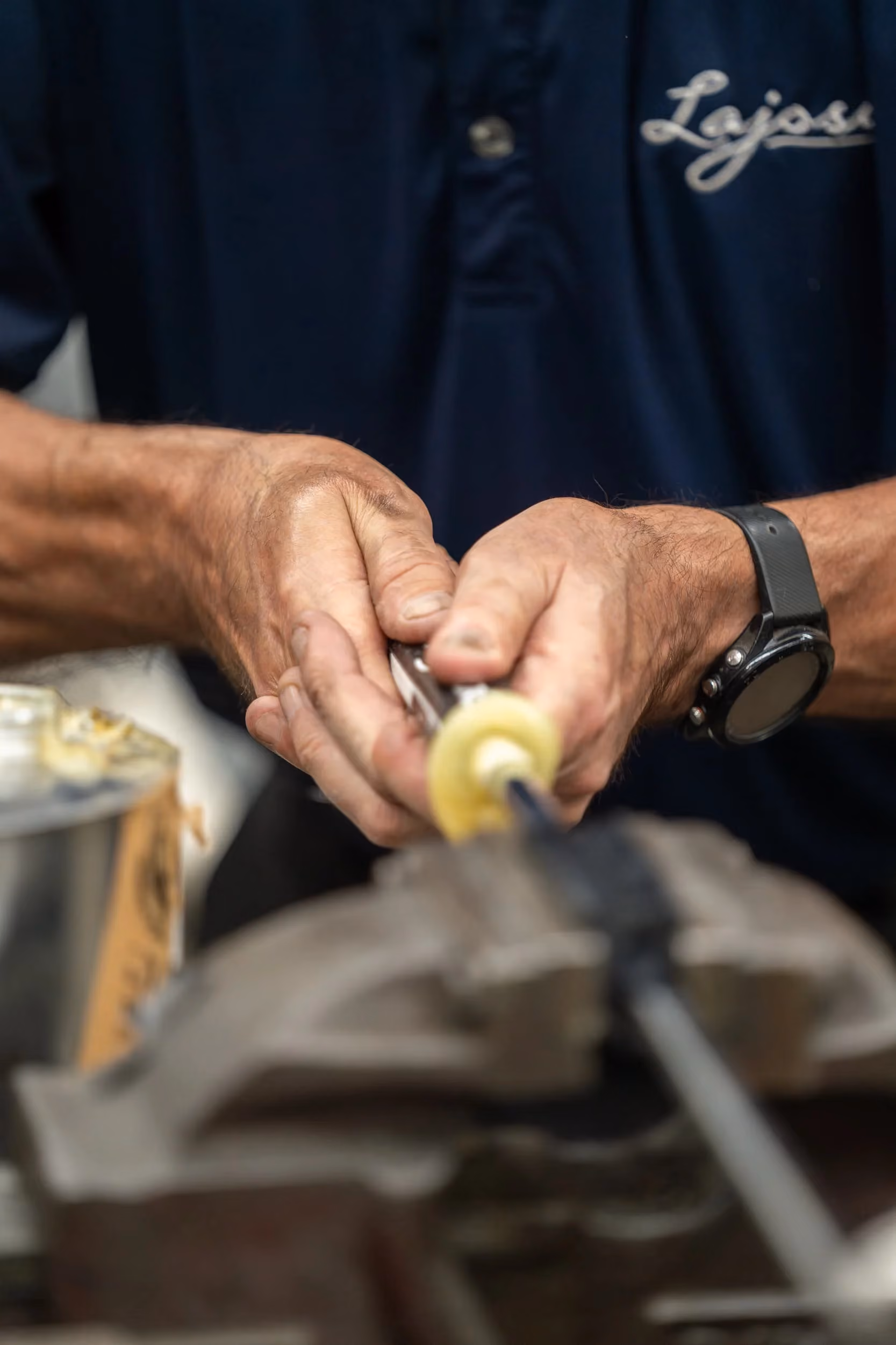 Kari Lajosi hand-finishing a custom putter component at the workbench, showing the precision, care and hands-on skill behind each handmade club.