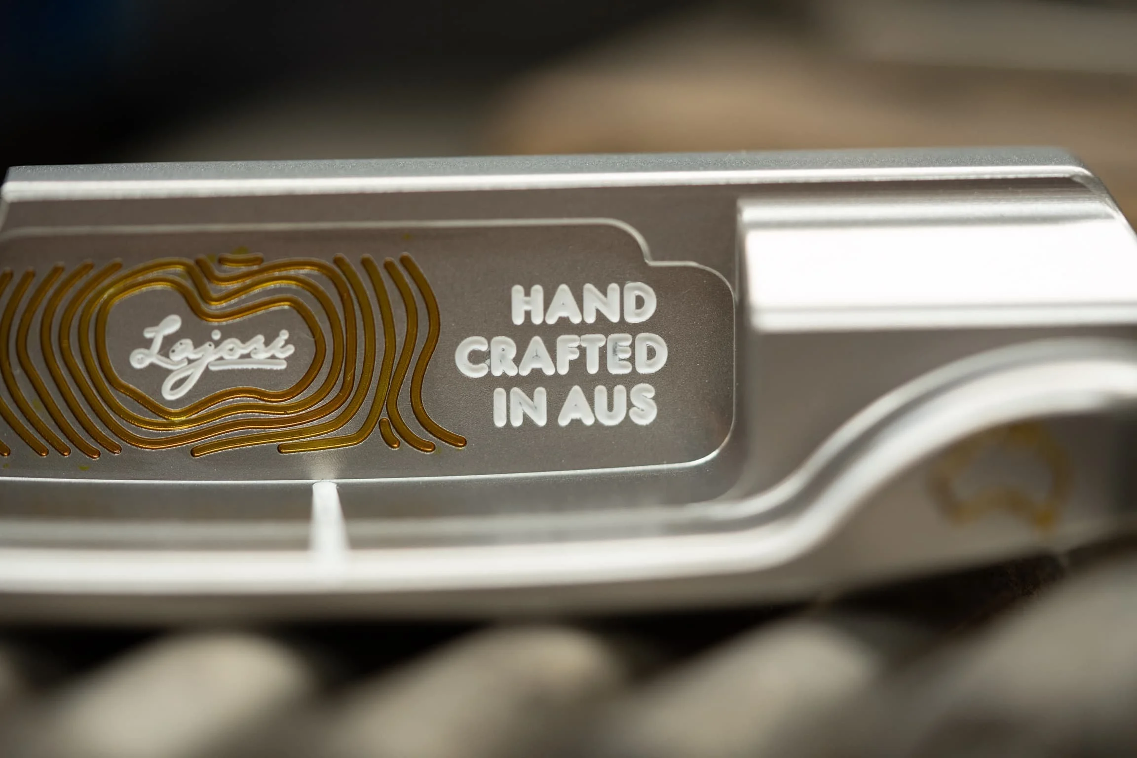 Close-up of a precision-milled Lajosi putter engraved with the logo and ‘Hand Crafted in Aus,’ reinforcing the brand’s Australian workshop heritage and handmade quality.
