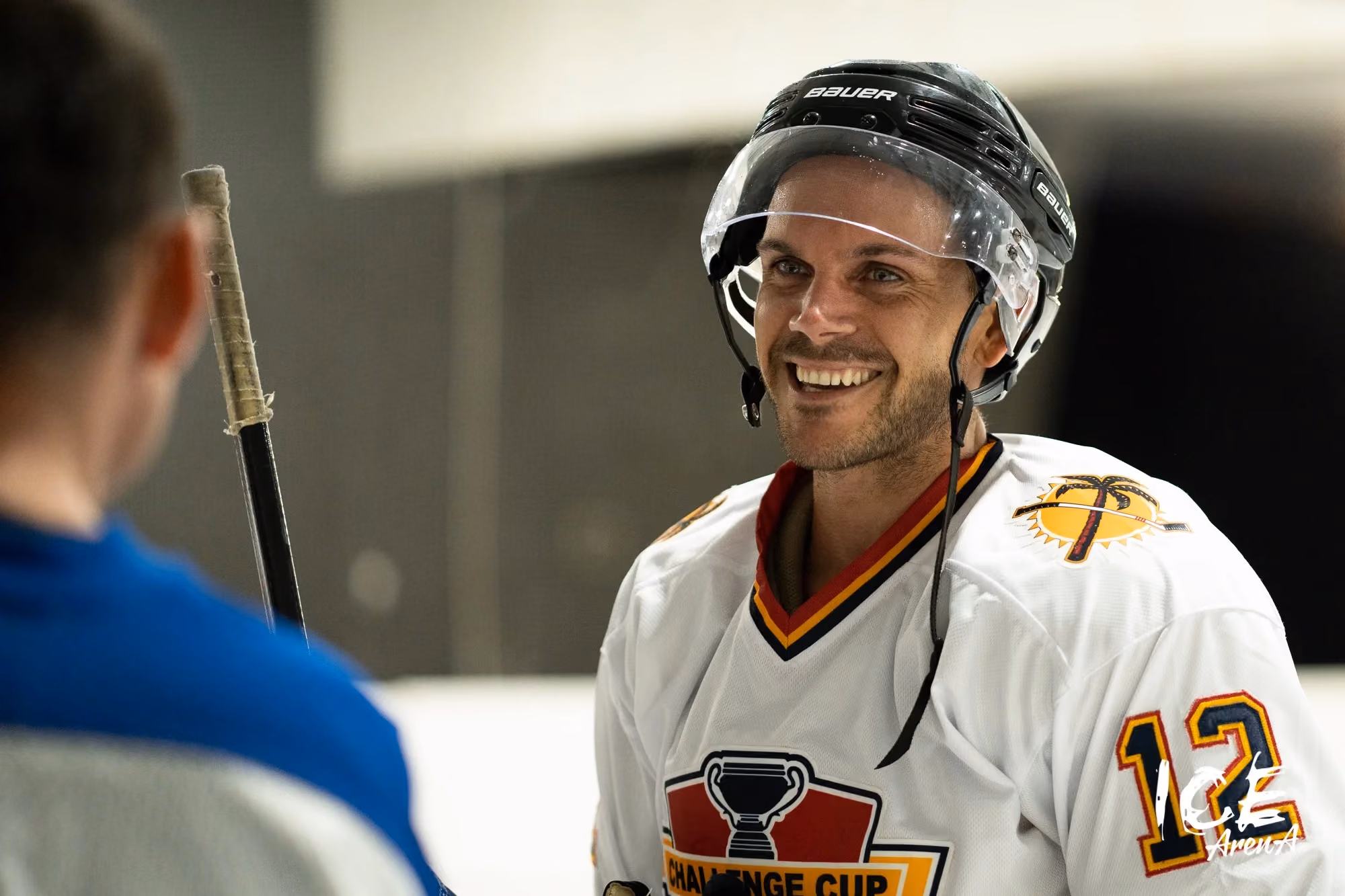 Smiling ice hockey player speaking with another skater at Ice Arena Adelaide, reflecting the welcoming social atmosphere and community experience built around the venue.