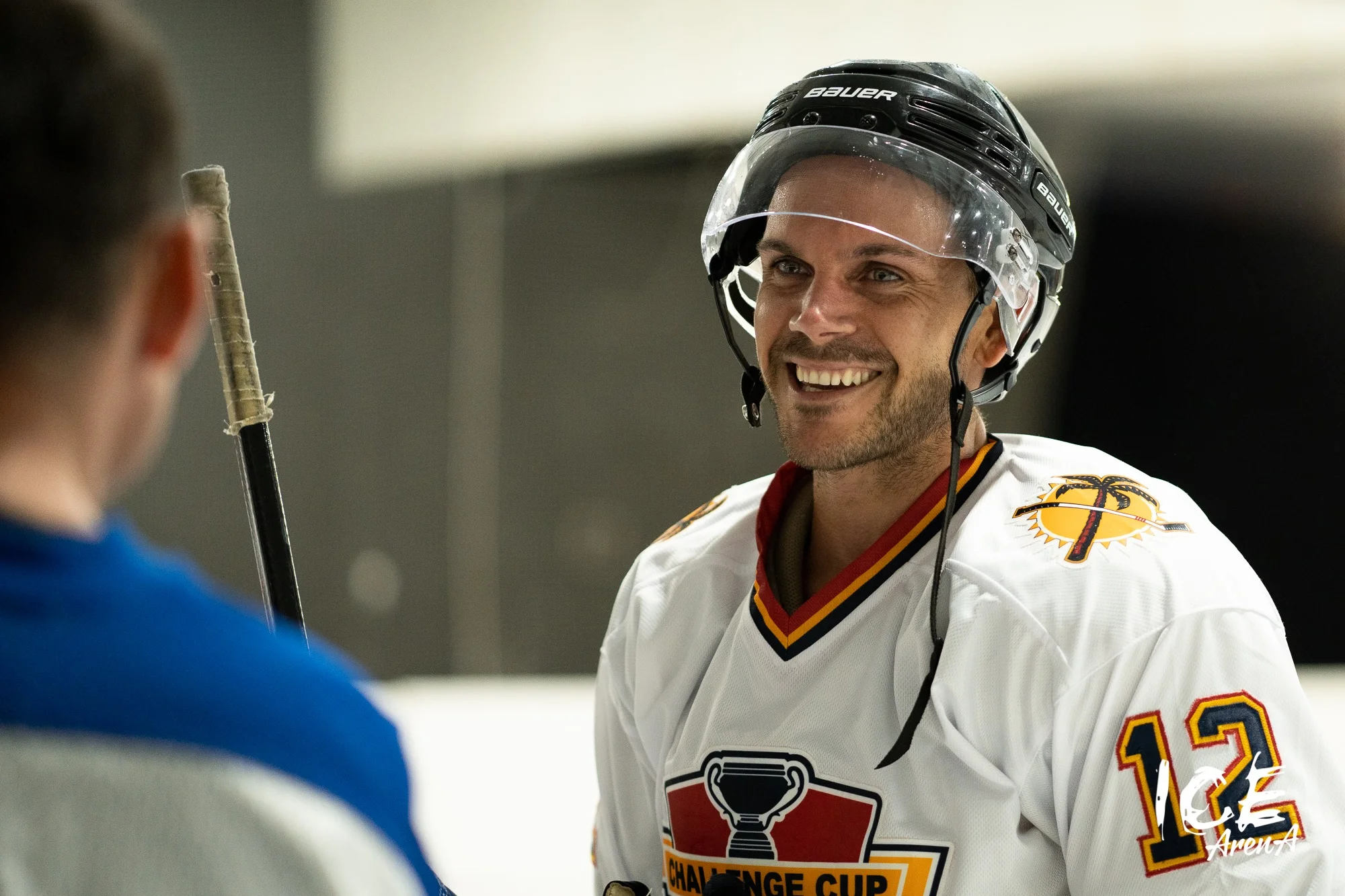 Smiling ice hockey player speaking with another skater at Ice Arena Adelaide, reflecting the welcoming social atmosphere and community experience built around the venue.