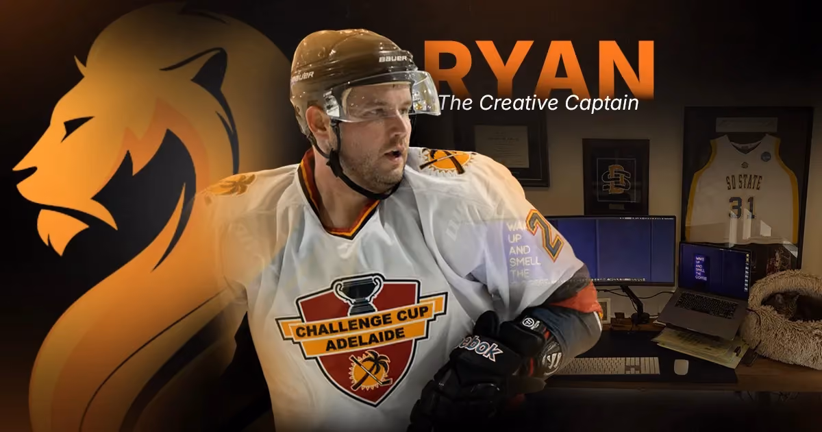 Ryan, Wandering Lion’s Creative Captain, wearing hockey gear beside his creative production workspace.