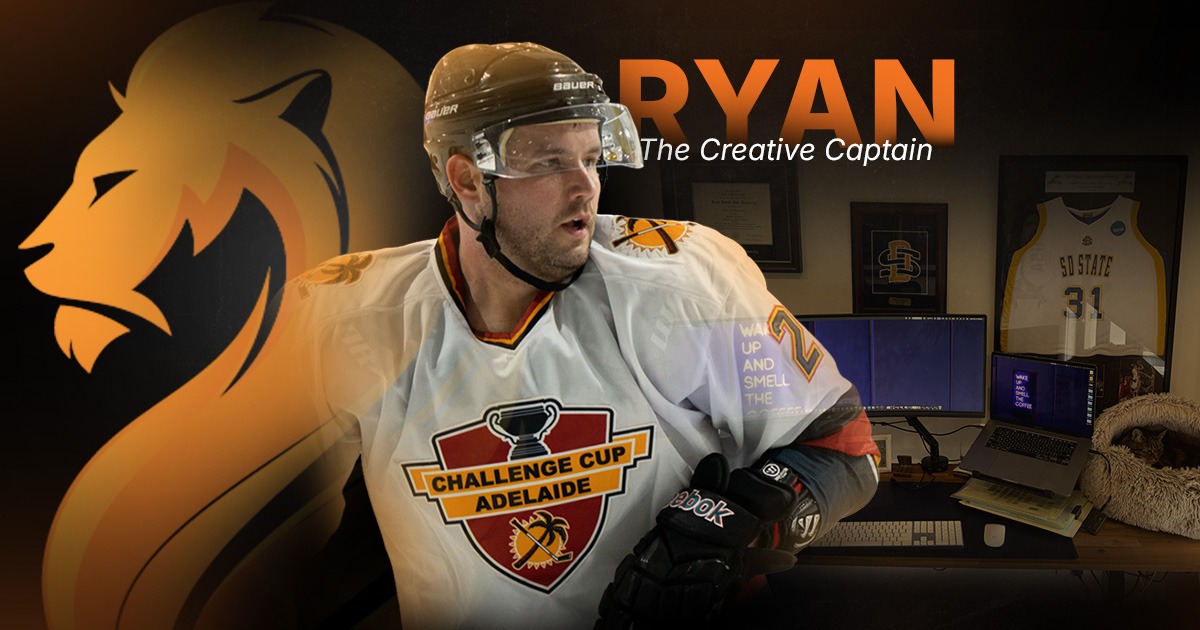 Ryan, Wandering Lion’s Creative Captain, wearing hockey gear beside his creative production workspace.