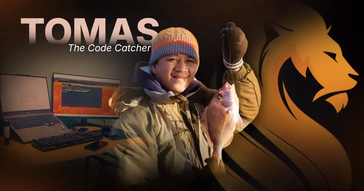 Tomas, Wandering Lion’s Code Catcher, holding a fish beside his web development and IT workspace.
