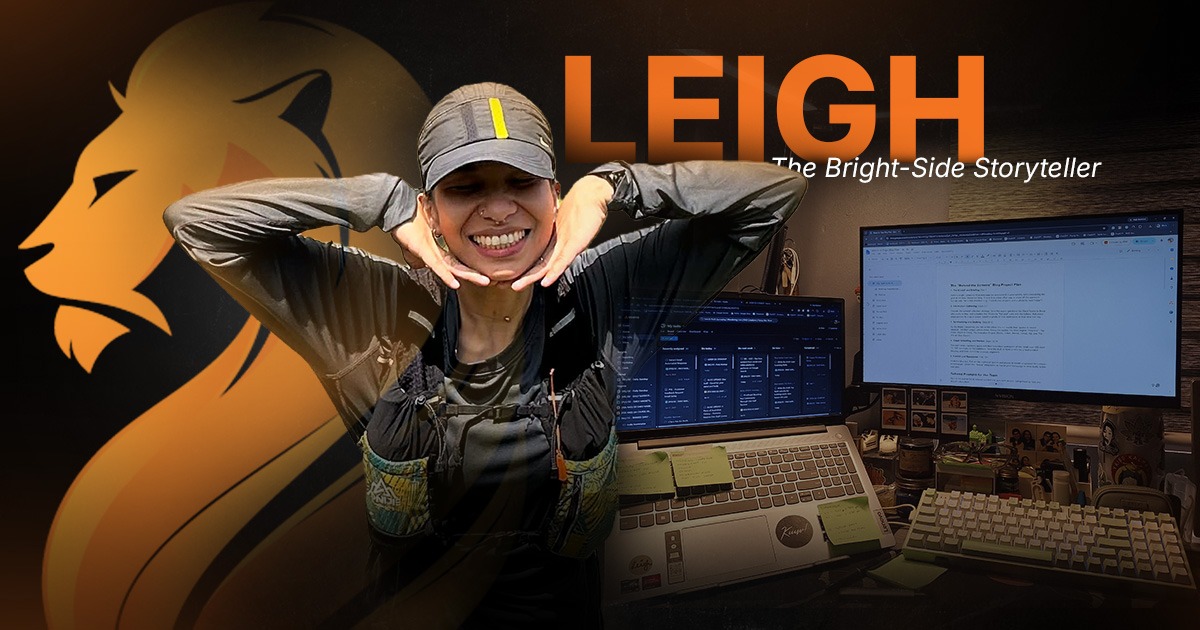 Leigh, Wandering Lion’s Bright-Side Storyteller, smiling beside her copywriting workspace and research screens.