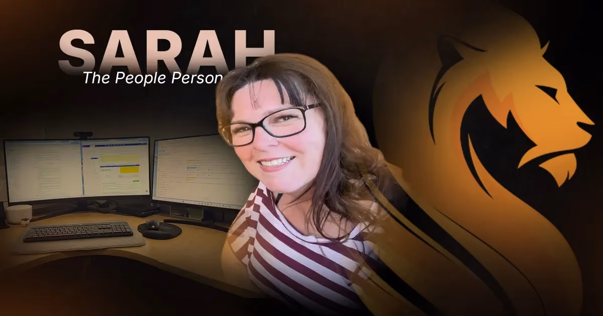 Sarah, Wandering Lion’s People Person, smiling beside the remote systems she uses to support the team.