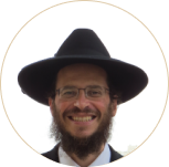 Smiling man with glasses, beard, and wide-brimmed black hat on a white background.