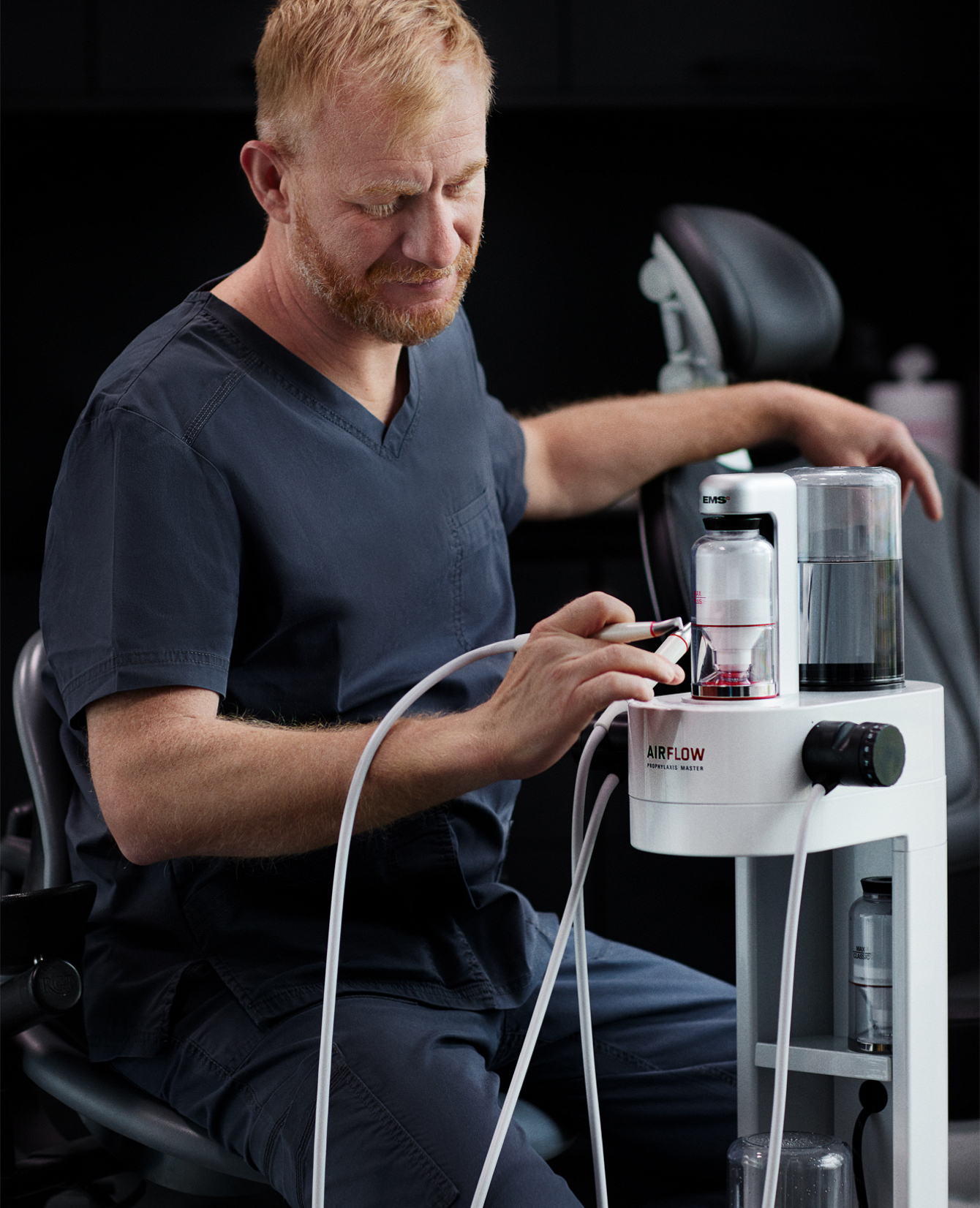 Dentist using the AIRFLOW unit during a cleaning