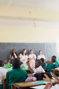 Four students presenting a lesson to the class of children.