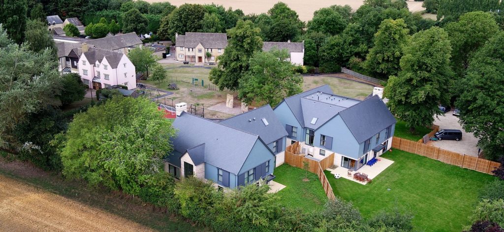 Long shot drone image of The Burrow, featuring group living houses in the back and the courtyard.
