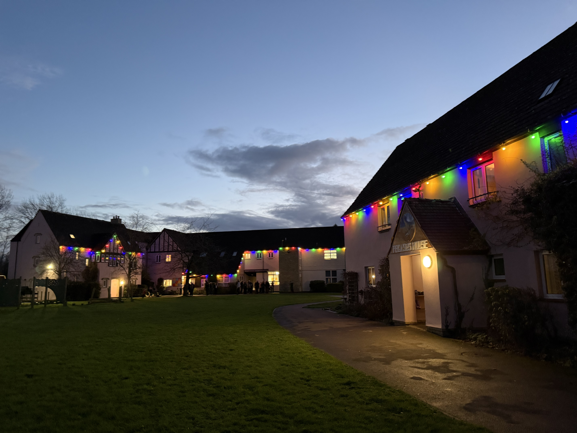 Landscape image of The Mulberry Bush Group Living Homes as the sunsets, with Christmas lights.