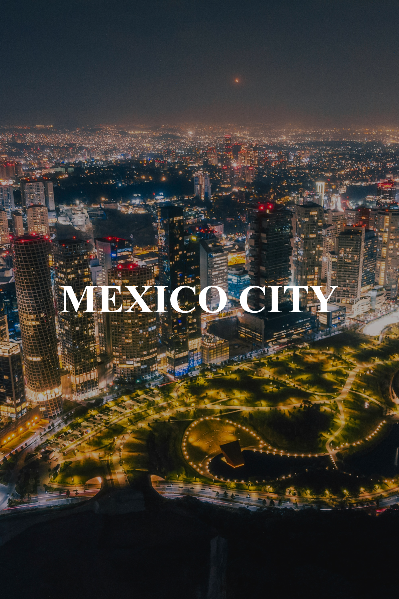 Mexico City éjszakai panorámája felhőkarcolókkal és kivilágított városi parkkal.