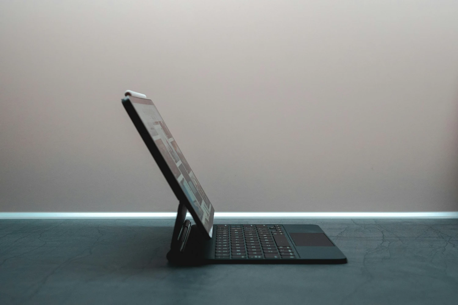 Notebook and pen beside a laptop displaying brand content drafts