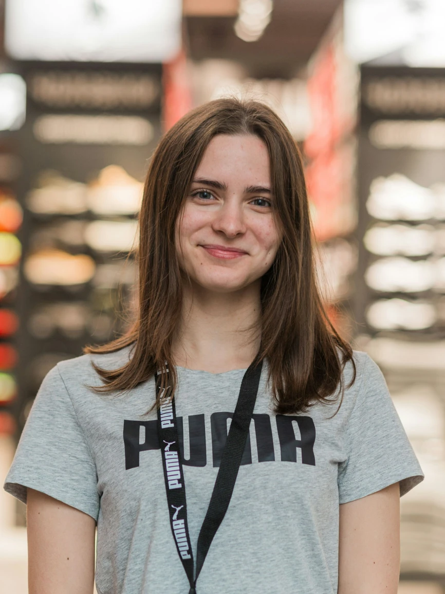 Professional studio headshot portrait of a smiling woman with straight hair against a neutral background