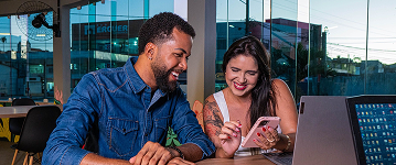 Couple laughing while looking at a phone