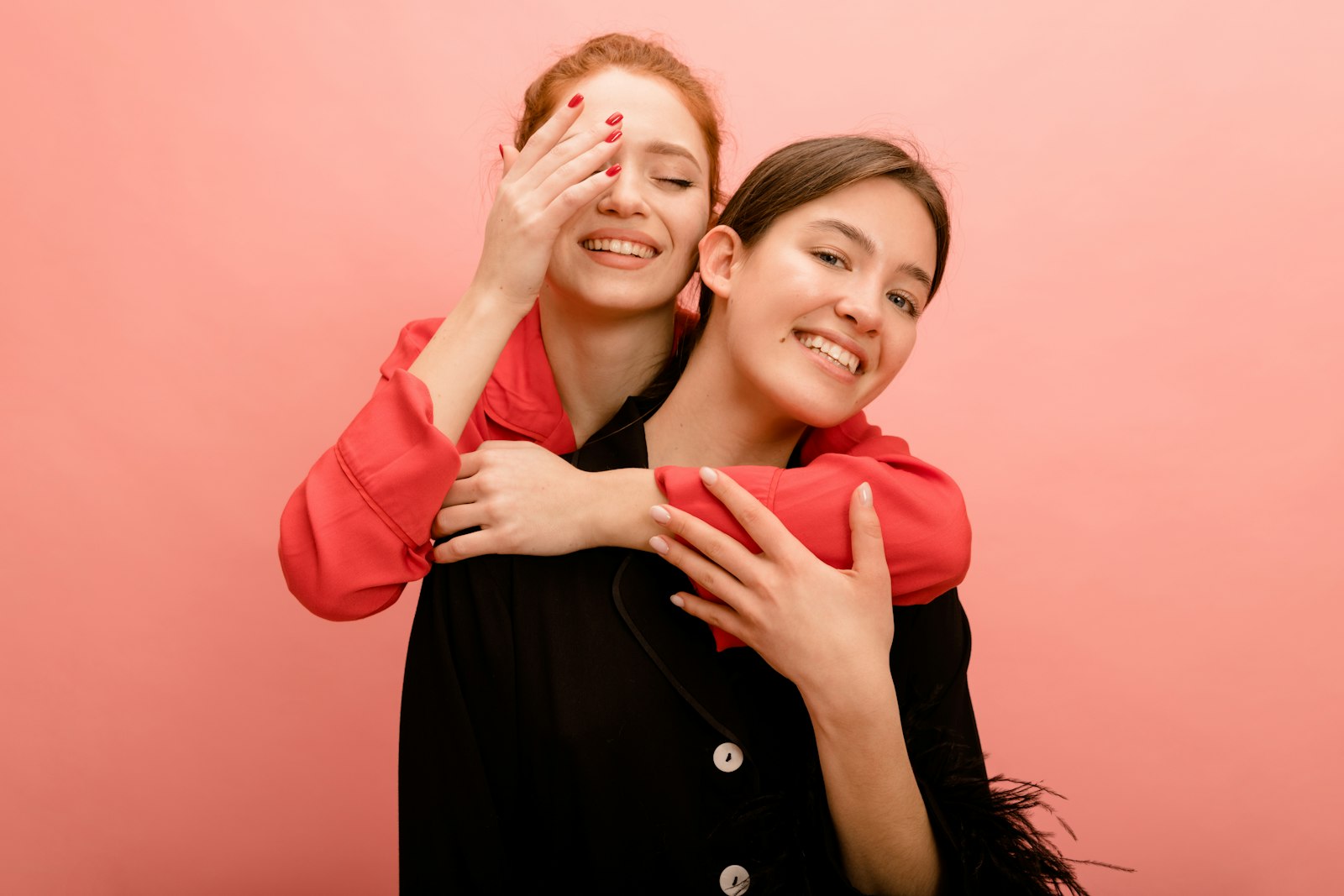 A woman surprising her smiling friend with a hug and a gift