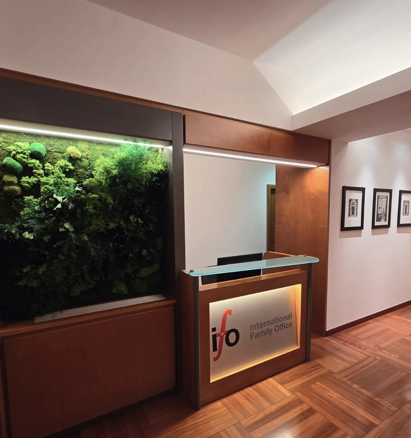 Reception dello studio IFO International Family Office con logo e parete vegetale.