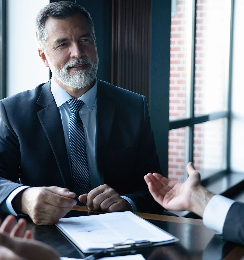 Consulente finanziario e cliente in dialogo riservato in ambiente elegante, toni scuri