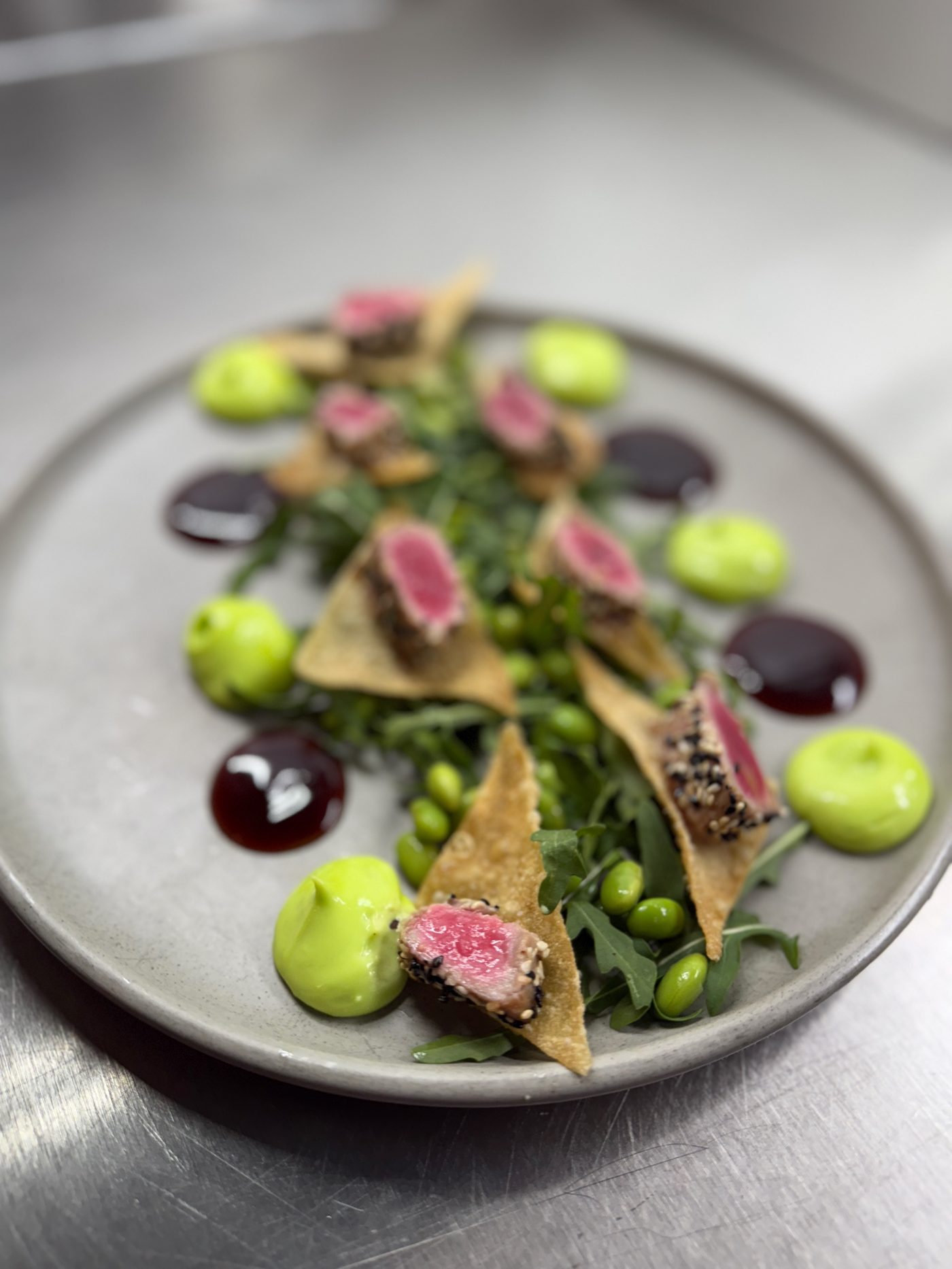 Seared tuna plated with avocado and edamame