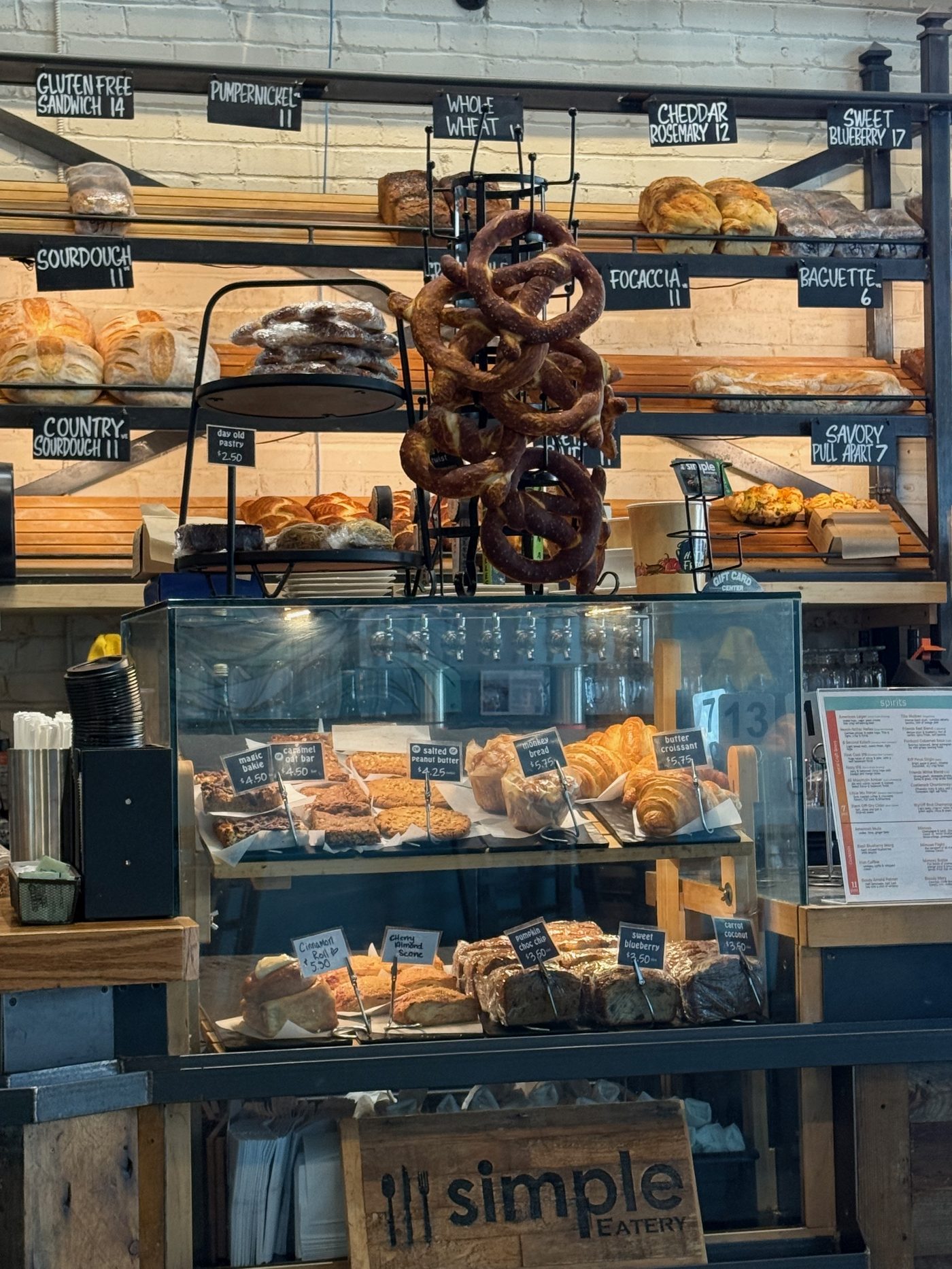 Bakery counter with fresh bread and pastries on wooden shelves