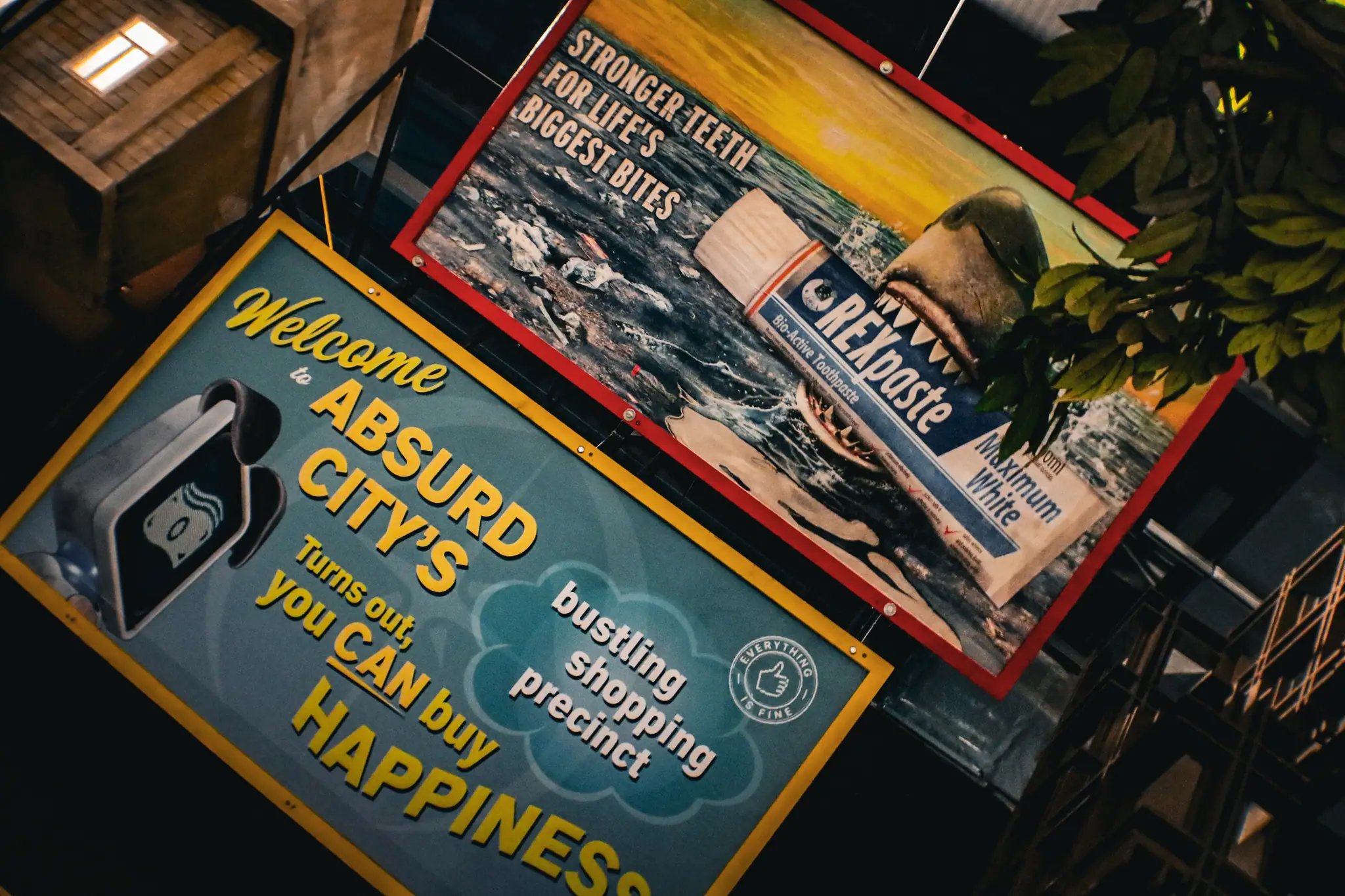 Two humoristic signs: one welcomes to Absurd City with shopping, another shows a shark biting a toothpaste tube.