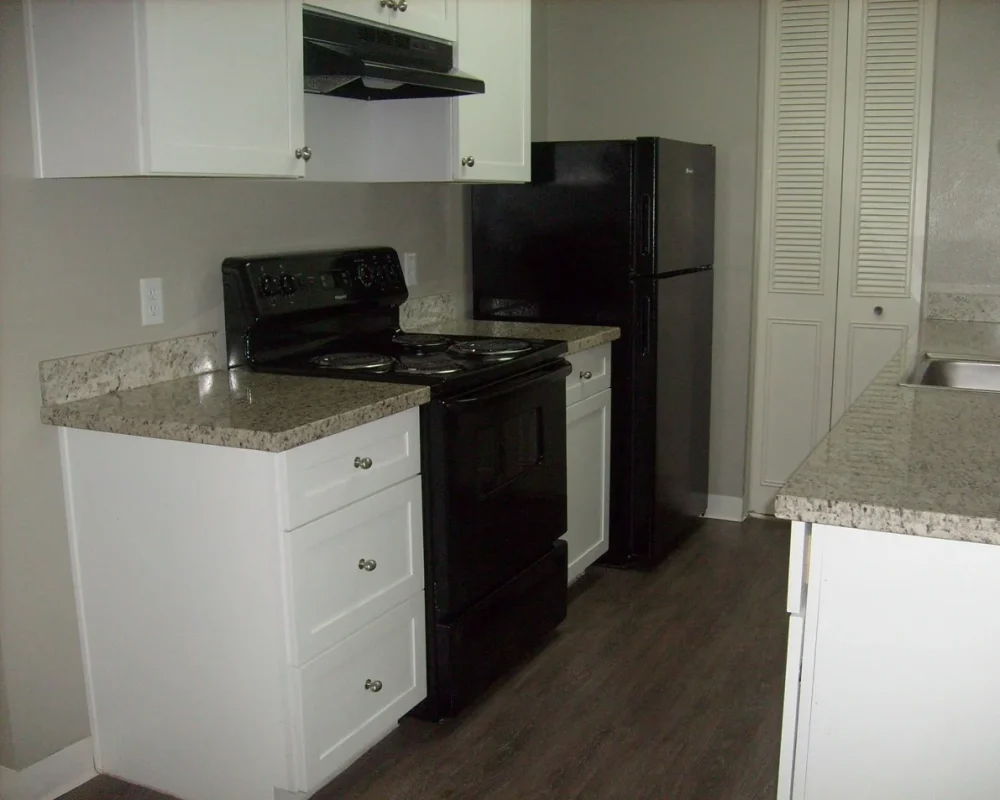 Kitchen with white cabinets and black appliances 