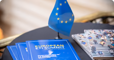 Drapeau de l'Union européenne sur une table avec des brochures du Sommet des ETF européen.