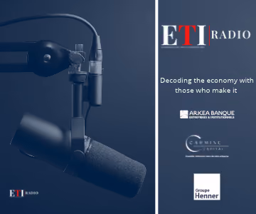 Microphone de studio suspendu sur un bras articulé sur fond bleu foncé à gauche, panneau avec logo ETI RADIO en blanc et rouge à droite, texte "Décoder l'économie avec ceux qui la font" suivi de logos d'Arkéa Banque, Carmine, et Groupe Henner.