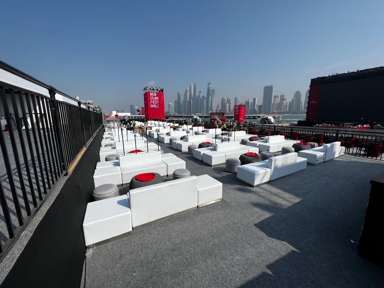 The same waterfront terrace dressed with rows of lounge seating against the Dubai skyline