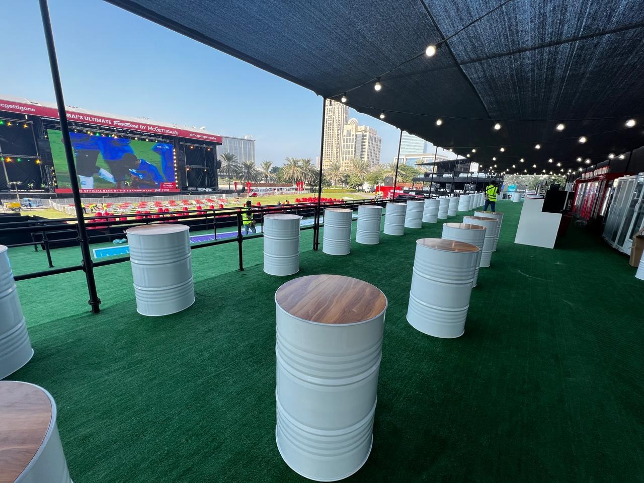 The same covered deck set as a standing bar run with drum tables along the screen side