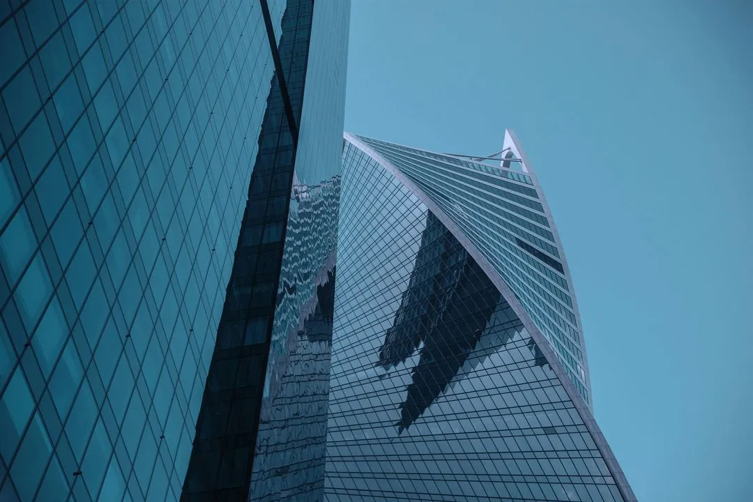 Striking modern skyscraper with a glass exterior, reflecting the cityscape and sky