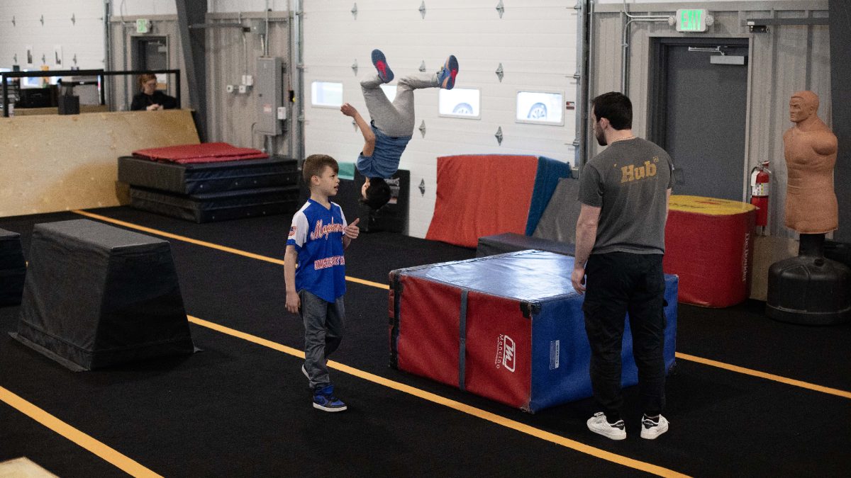 Coach demonstrating a flip at HUB Parkour Norfolk.
