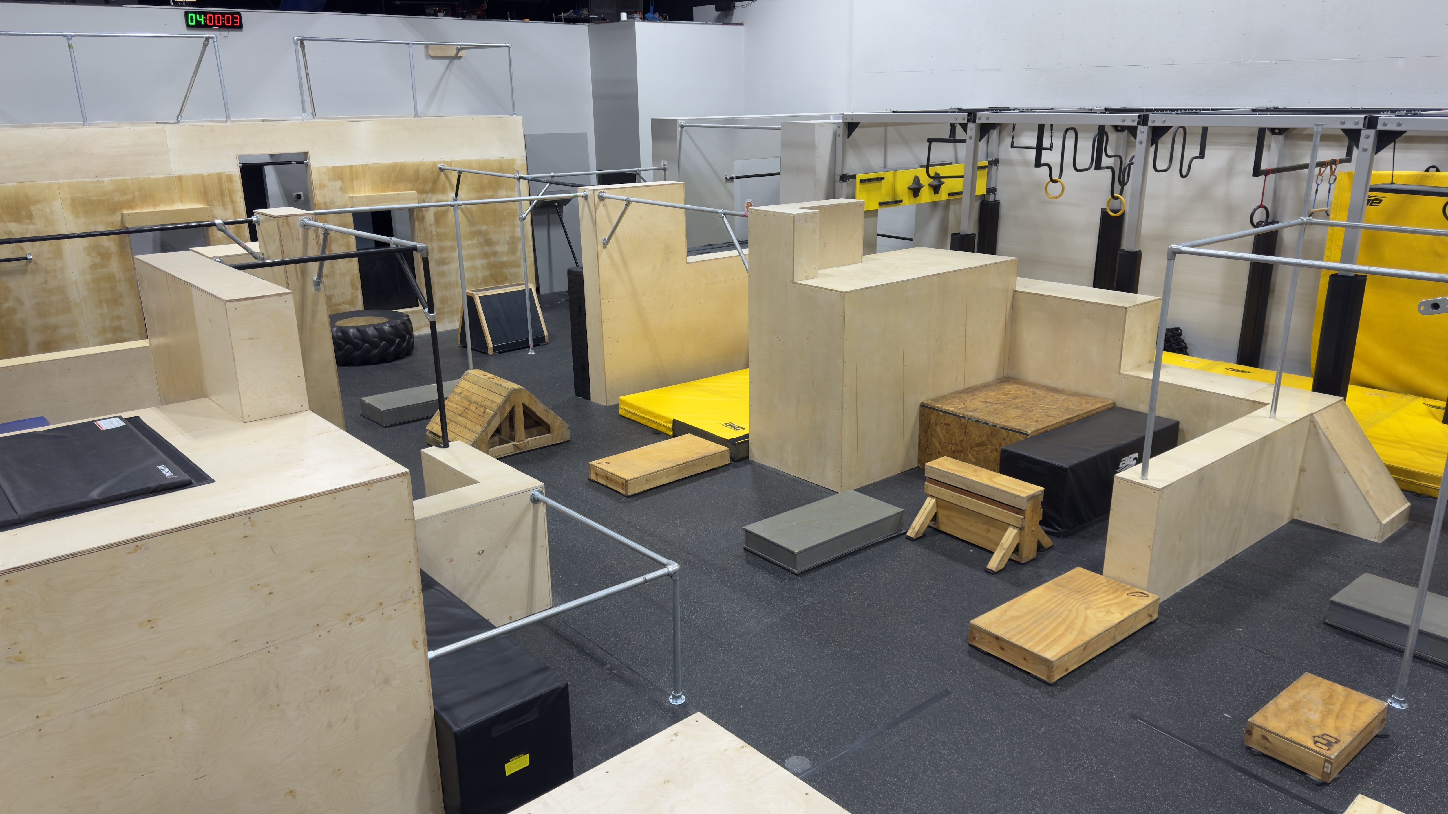 Wide view of the wooden obstacles, rails, and training floor at HUB Parkour Sudbury.