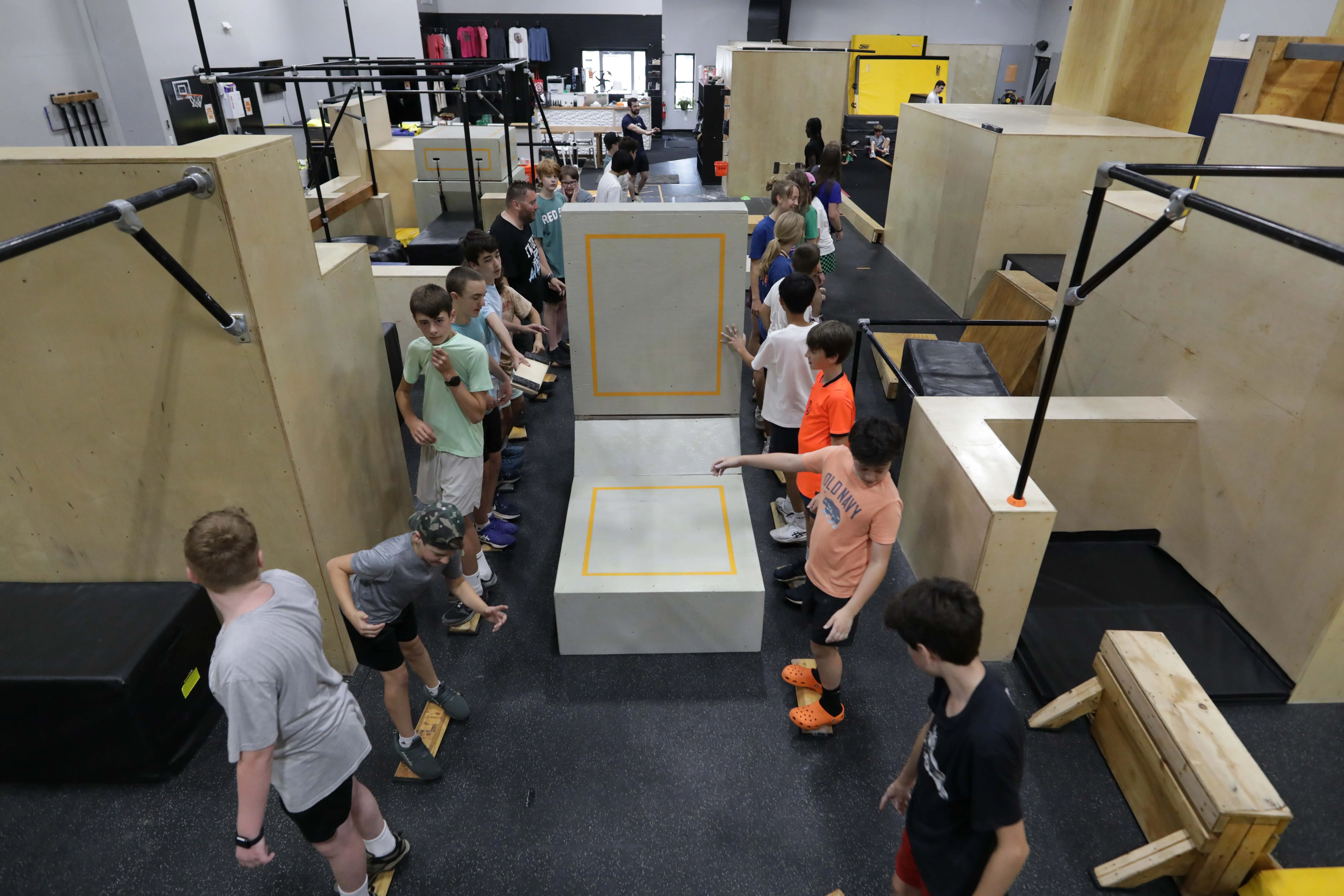 CampHUB athletes and coaches gathered around a central parkour obstacle.
