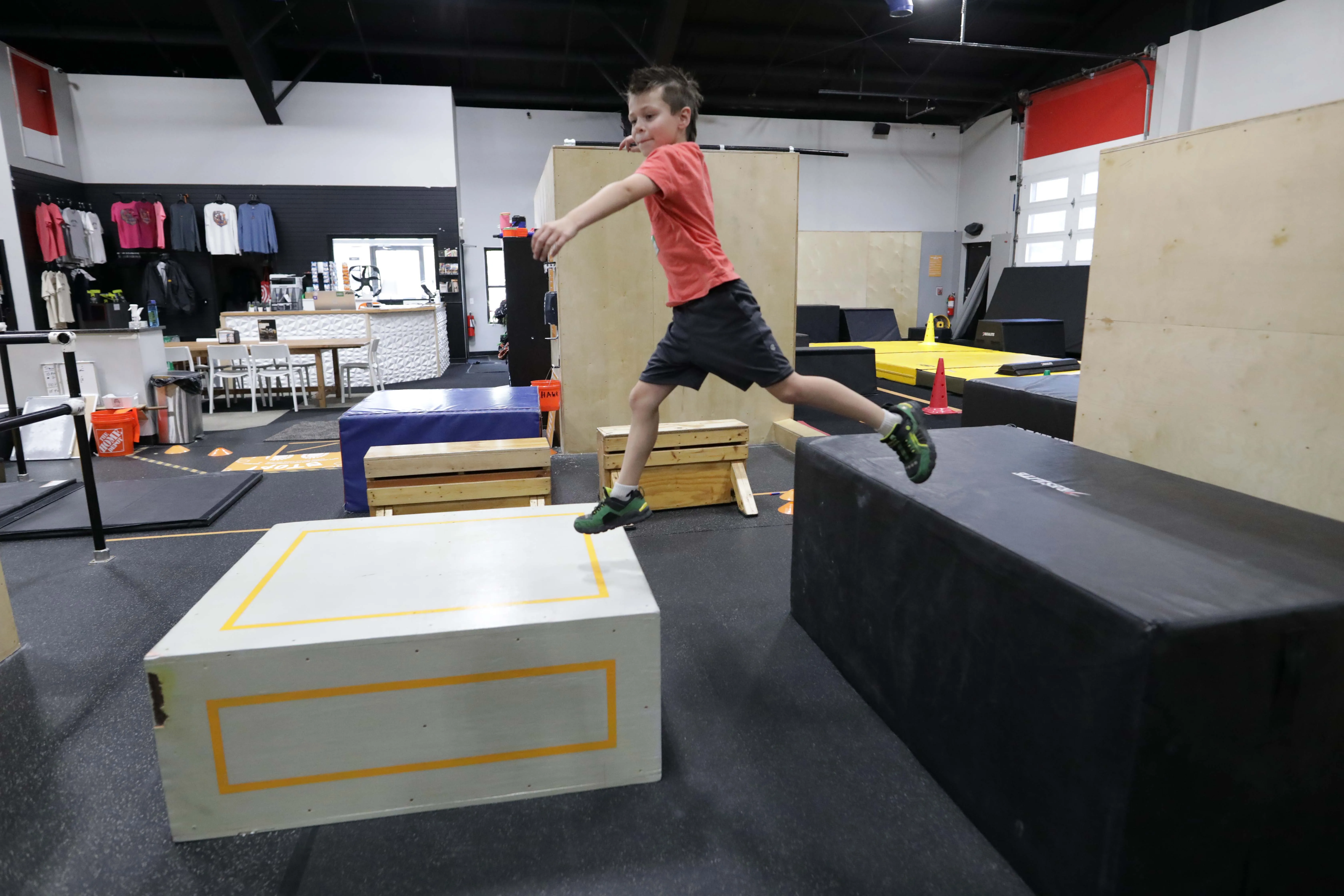 Young camper jumping between parkour boxes.
