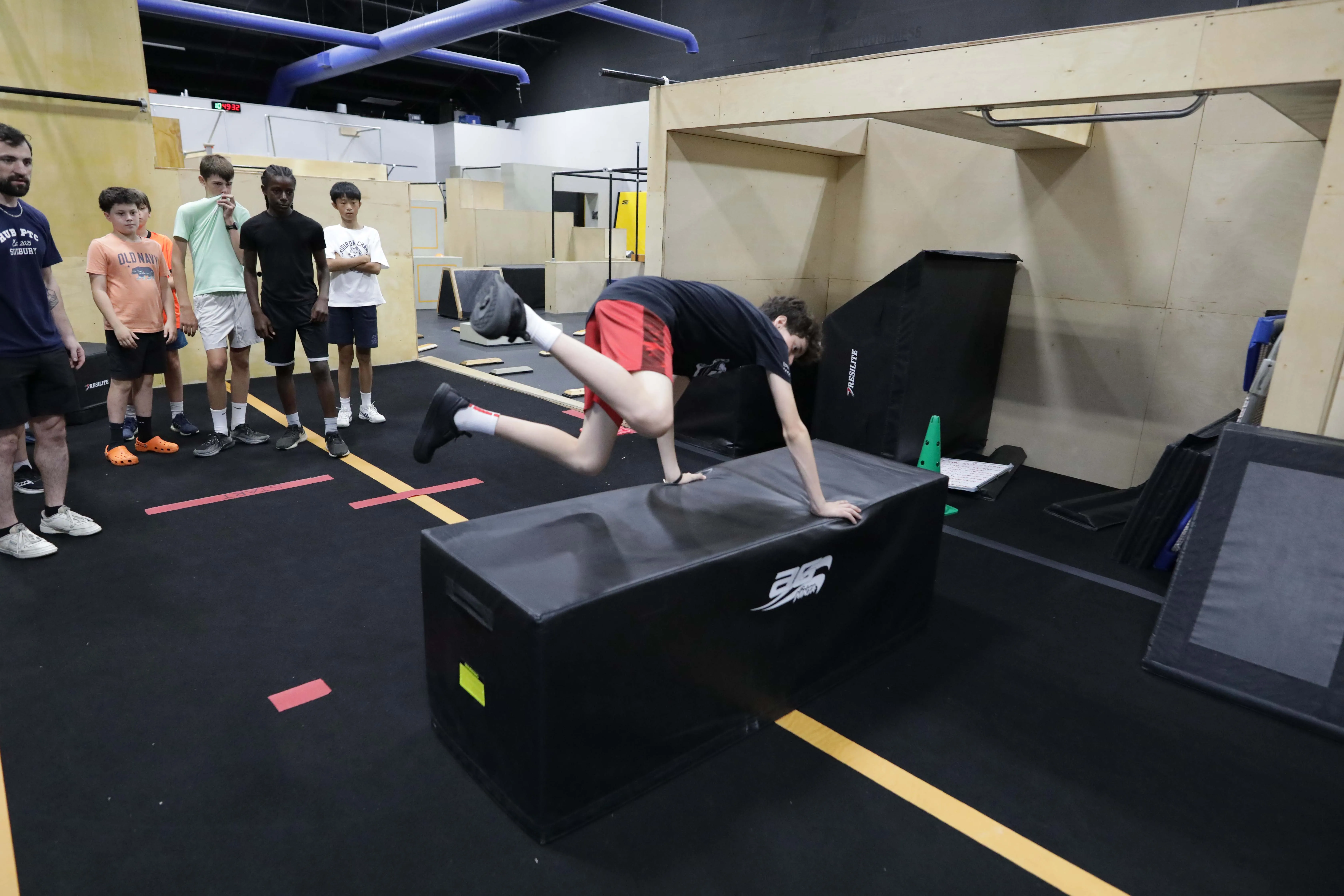 Athlete practicing a vault over a padded block during a HUB class.