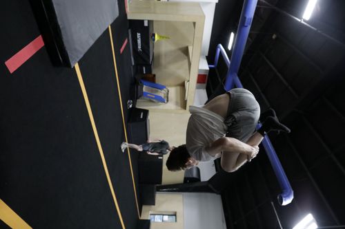 Adult athlete practicing an aerial tuck at HUB Parkour Sudbury.
