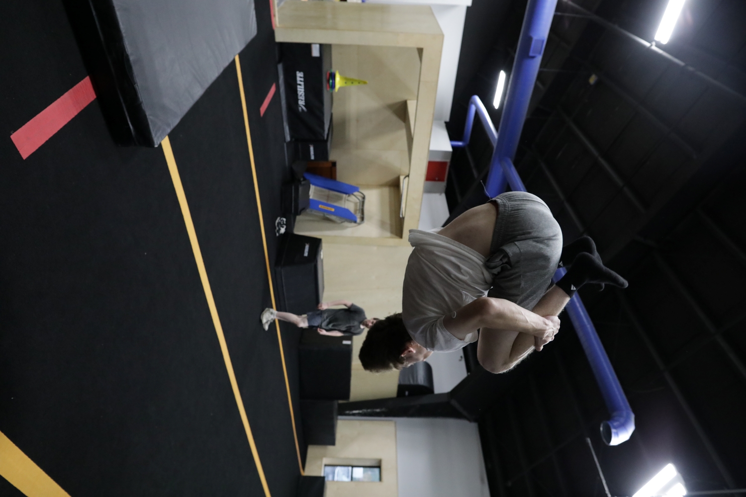 Adult athlete practicing an aerial tuck at HUB Parkour Sudbury.