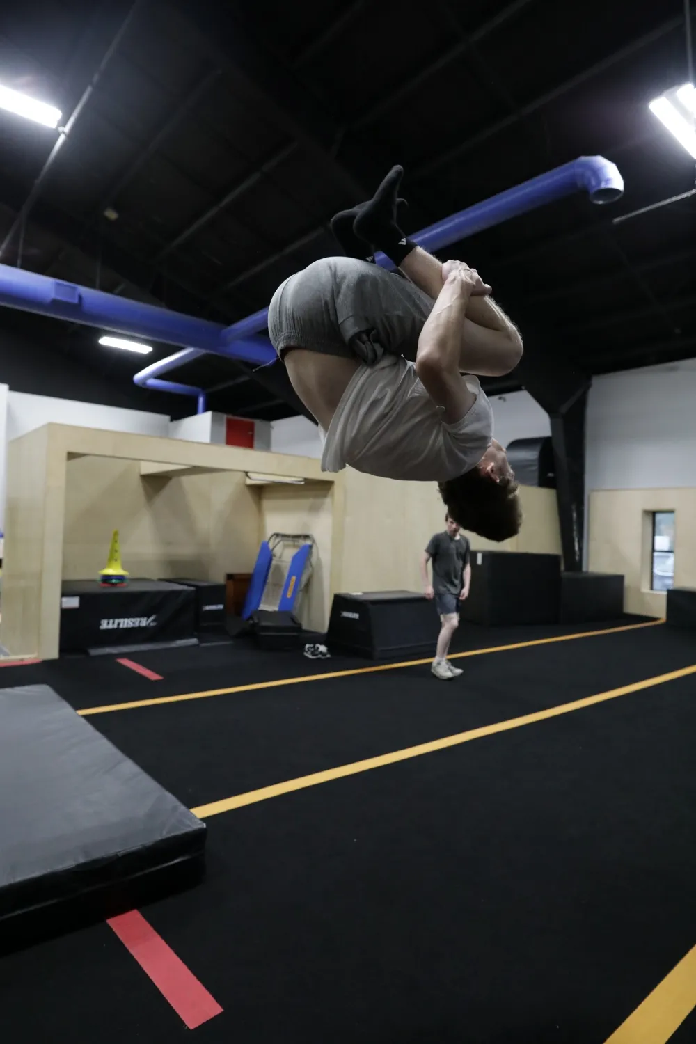 Adult athlete practicing an aerial tuck at HUB Parkour Sudbury.