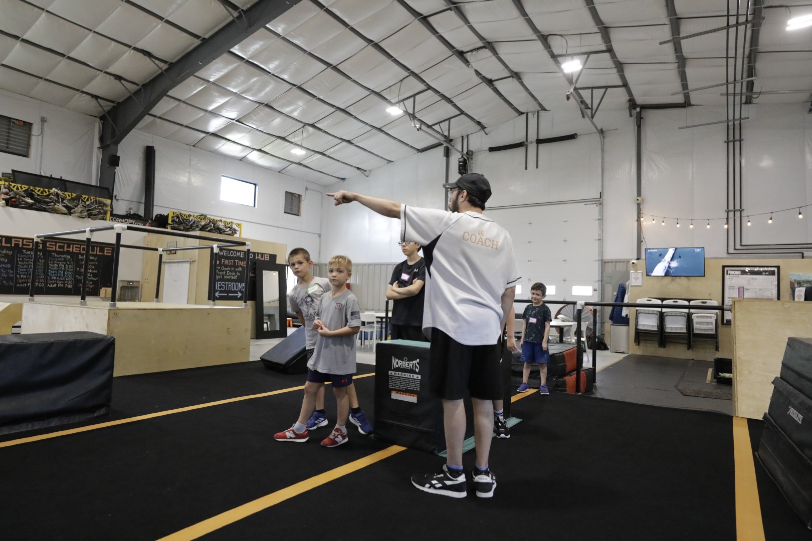 A HUB coach guiding children through an activity at the Norfolk gym