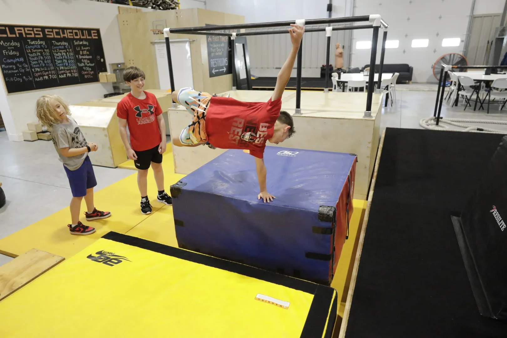 Campers cheer as a friend vaults onto a padded box
