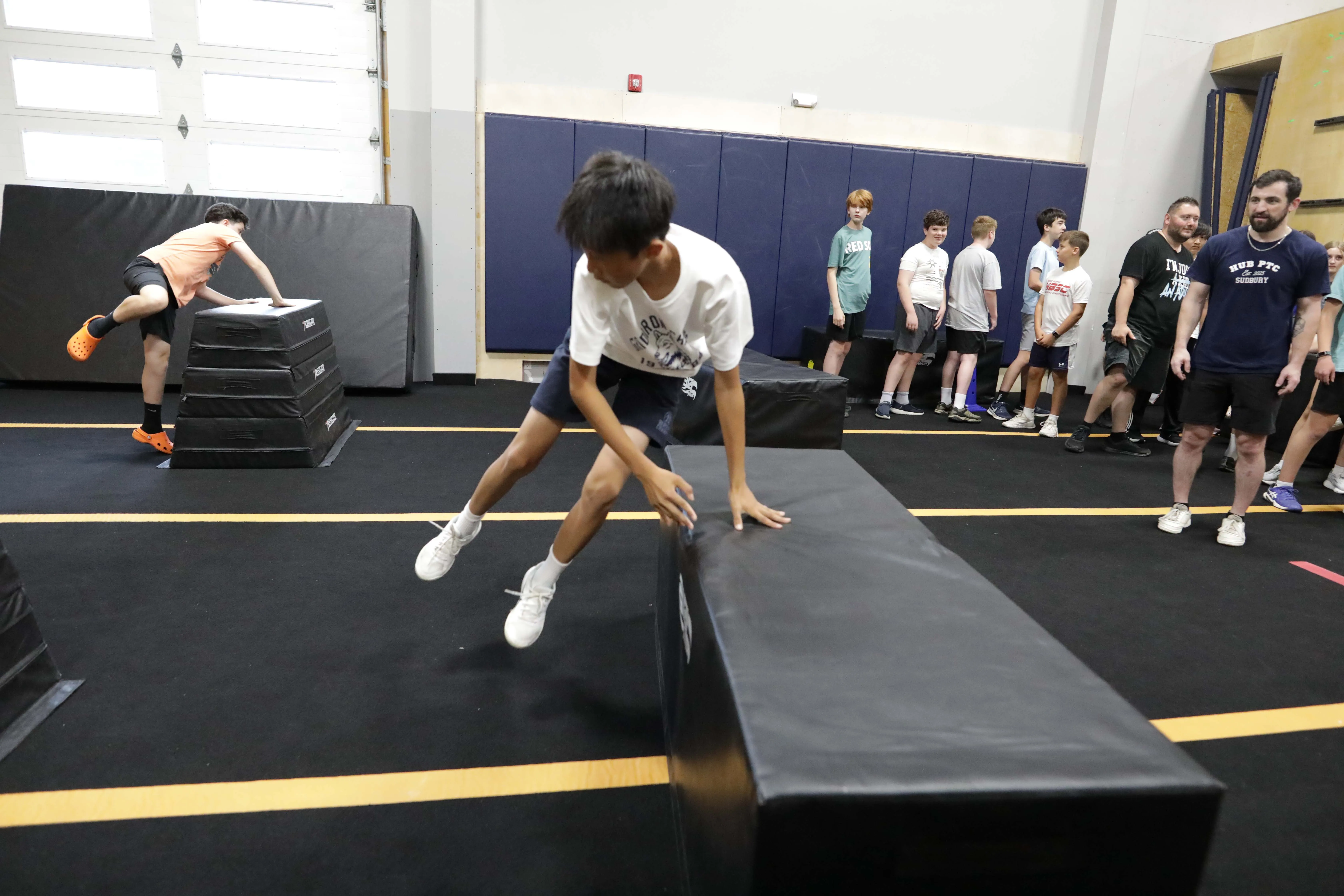 A teen moves across the gym floor while his small group watches